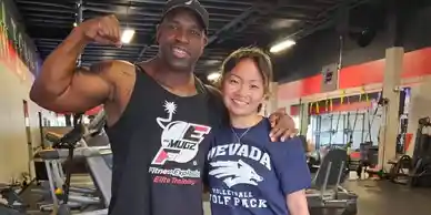 Coach Mugz and member flexing after training session