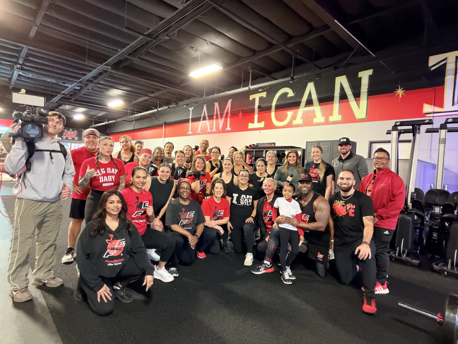 Full Fitness Explosion Fit Fam group photo under I AM I CAN I WILL wall