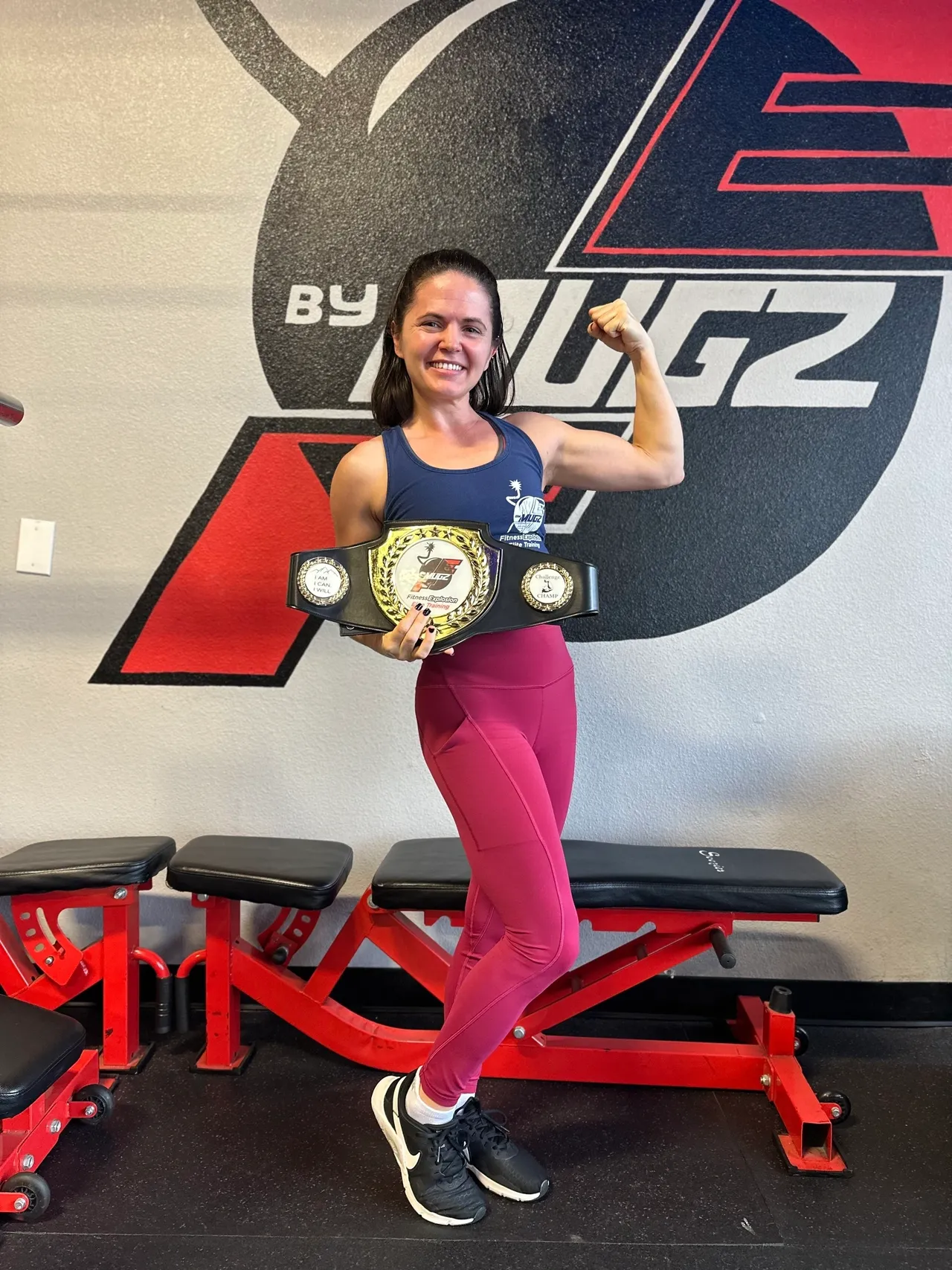 Fit Fam member flexing with championship belt