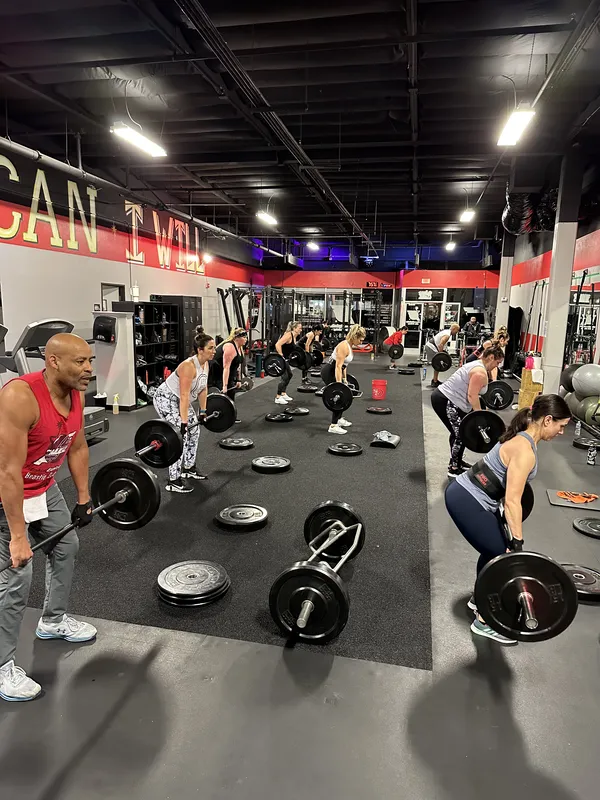 Bootcamp class — wide gym shot with members and barbells