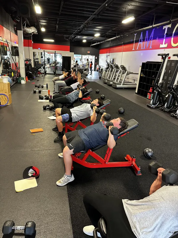 Members doing dumbbell bench exercises during class