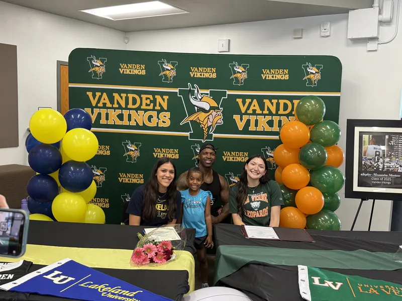 Vanden Vikings signing day ceremony — athlete with family and balloons