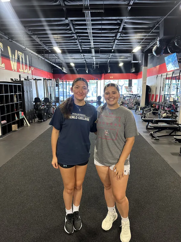 Two FE-trained athletes posing together at the gym