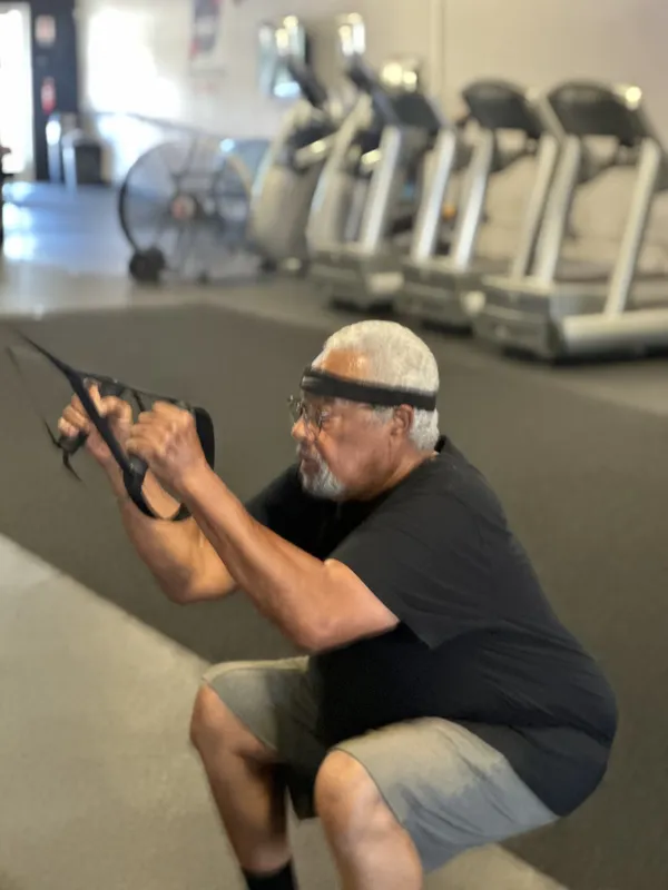 Senior member doing TRX exercises — all ages welcome at FE