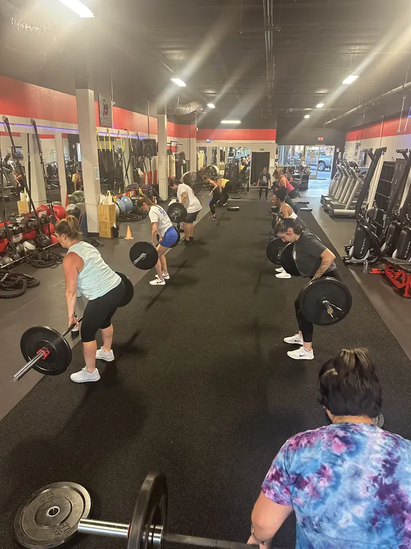 Group doing barbell squats during bootcamp