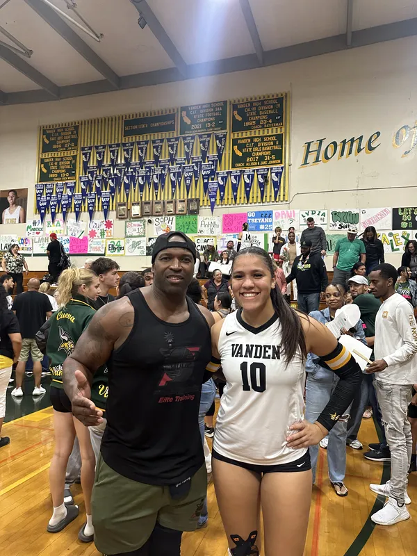 Coach Mugz cheering with FE athlete at Vanden volleyball game